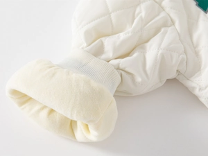Detail of white quilted jacket sleeve with fleece lining and ribbed cuff for kids