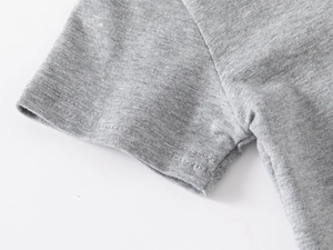 Detail of double-needle stitching on the cuff of a grey boys' cotton polo shirt