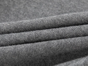 Gros plan sur un tricot gris doux montrant la texture détaillée du tissage plat