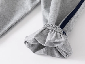 Detail of light gray ribbed cuffs with navy side stripes on kids' cotton jogger pants