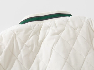 Close-up of quilted white jacket with striped green and grey knitted baseball collar detail