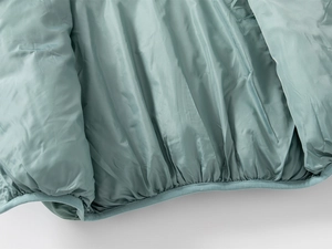 Detailed close-up of light green quilted inner lining and premium fabric edge stitching