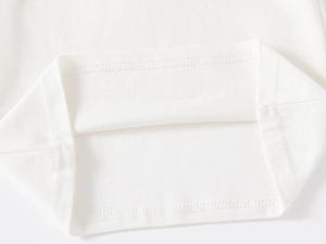 Macro detail of the double-stitched hem and breathable mesh fabric on white polo shirt