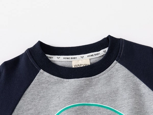 Detail of boys' sweatshirt featuring navy rib neckline and WAPYPY brand label