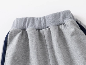 Detailed macro view of the wide ribbed elastic waistband on boys gray sports joggers