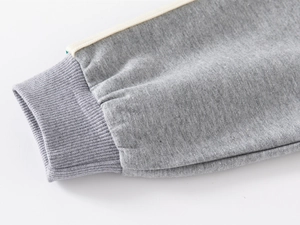Detail of ribbed gray knit cuff with stylish side stripe on a children's casual tracksuit