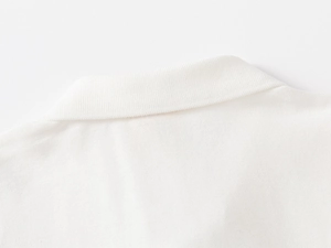Detailed close-up of white pique polo shirt collar with ribbed texture and neat stitching
