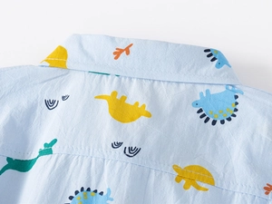 Détail macro du col de chemise en coton pour enfant avec motifs de dinosaures colorés