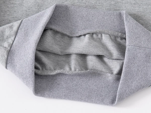 Detailed macro view of the grey ribbed knit cuffs and soft fleece lining of the kid's sweatshirt