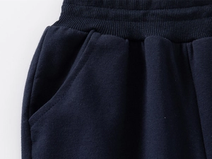 Detailed macro view of dark blue joggers with elastic waistband and side pockets