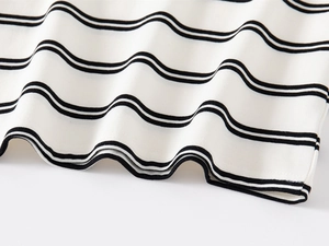 Detailed close-up of soft knit fabric hem with classic black and white horizontal stripes
