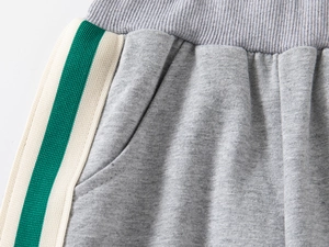 Close-up of kids grey joggers elastic waistband with green and white side stripes