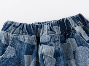 Macro detail of elastic waistband and blue geometric jacquard denim texture on kids shorts