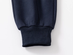 Detail of dark blue ribbed elastic cuffs on boys sports pants with thick knit texture
