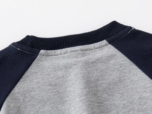 Detail of ribbed neckline and navy raglan sleeves on casual grey cotton blend sweatshirt
