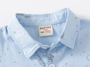 Close-up of baby boy light blue cotton shirt with astronaut print and collar tag details