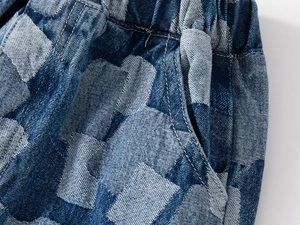 Detail of boys' denim shorts featuring elastic waist and blue checkerboard pattern