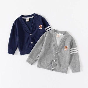 Detail of kids knit cardigan featuring baseball bear embroidery and sleeve stripes