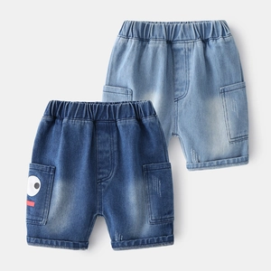 Detail of kids denim shorts featuring elastic waistband and embroidered pocket design