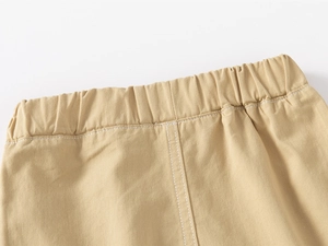 Close-up of boys khaki cotton shorts with elastic waistband and white stitching details