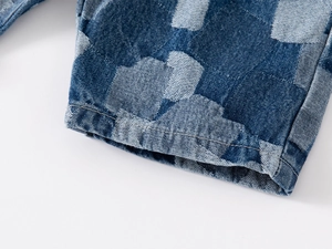 Macro view of denim kids shorts featuring contrast patchwork patterns and stitching