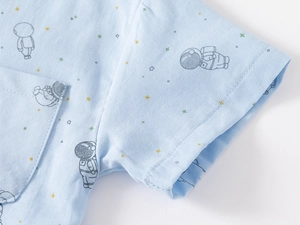 Detail of light blue short sleeve shirt with astronaut patterns and pocket stitching
