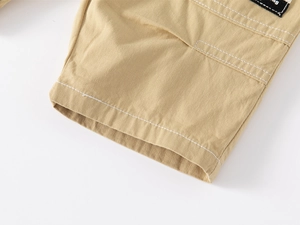 Detail of khaki twill cotton shorts featuring white double stitching and a black woven label