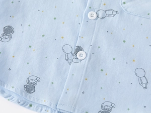 Macro shot of light blue cotton shirt fabric texture with cartoon astronaut pattern