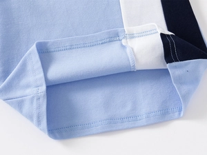 Detail of color-block kids polo shirt showing high-quality stitching and mesh fabric texture