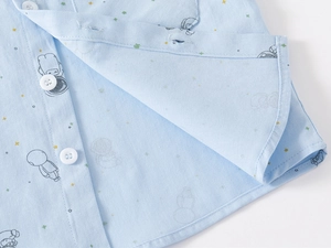Detail of light blue cotton shirt featuring astronaut print and white round buttons