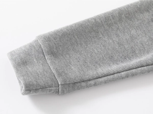 Close-up of grey cotton sweatshirt sleeve with detailed ribbed cuff and knit texture