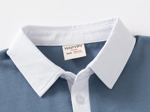 Close-up of contrast white collar and buttons on a blue cotton children's Polo shirt