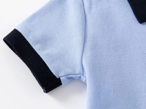 Close-up of light blue polo shirt featuring navy ribbed cuffs and knit pique texture