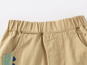 Détail du short garçon en coton kaki avec taille élastique et imprimé dinosaure coloré