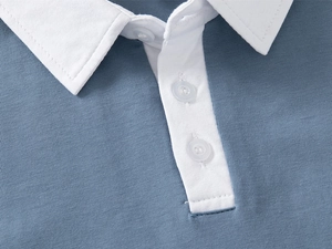 Close-up of contrast collar and button detail on blue knit kids polo shirt