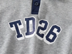 Detailed view of the gray knitted cotton sweatshirt featuring the TD26 printed logo
