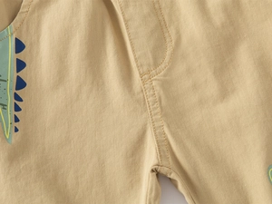 Détail du short enfant en coton kaki avec imprimé dinosaure bleu et coutures soignées