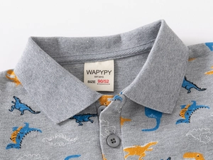 Detailed view of the dinosaur print fabric and polo collar on grey boys' cotton shirt
