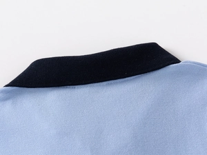 Close-up of polo shirt collar showing navy ribbing and light blue pique fabric texture