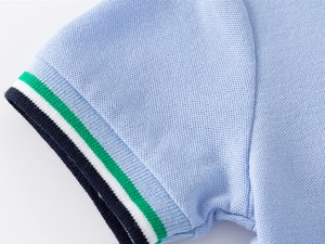 Detail of light blue pique cotton polo sleeve with colorful striped ribbed cuffs