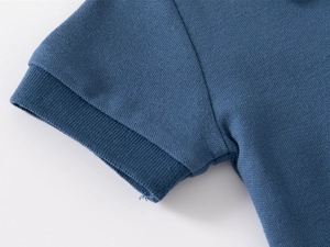 Détail de la manche d'un polo bleu marine en coton piqué avec texture respirante