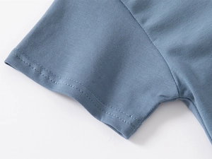 Detail of the sleeve cuff on a blue cotton polo shirt with neat double-needle stitching