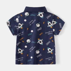 Detail view of navy blue kids' polo shirt featuring space-themed rocket and planet patterns