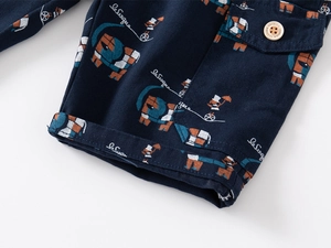 Close-up of navy blue cotton shorts featuring circus elephant prints and wooden button detail