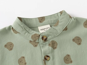 Close-up of the mandarin collar on a green kids shirt with a cute brown bear pattern