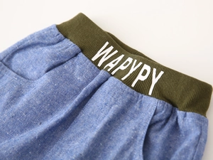 Detail view of boys light blue cotton linen shorts with olive green elastic waistband