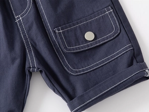 Detailed close-up of navy cotton cargo shorts featuring flap pockets and contrast stitching