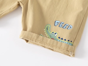 Détail du short en coton kaki avec imprimé crocodile et design à ourlet retroussé