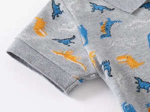 Detail of piqué cotton fabric and dinosaur print on grey short sleeve polo shirt