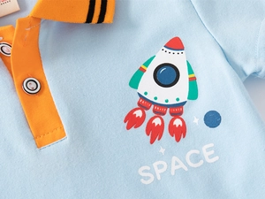 Detail of blue cotton polo shirt with orange collar, white buttons, and space rocket print